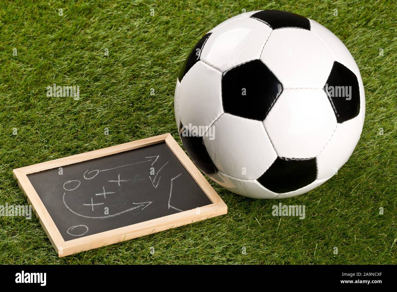 Sport soccer ball con gioco strategia lavagna di disegno su sfondo di erba - Il fuoco selettivo Foto Stock