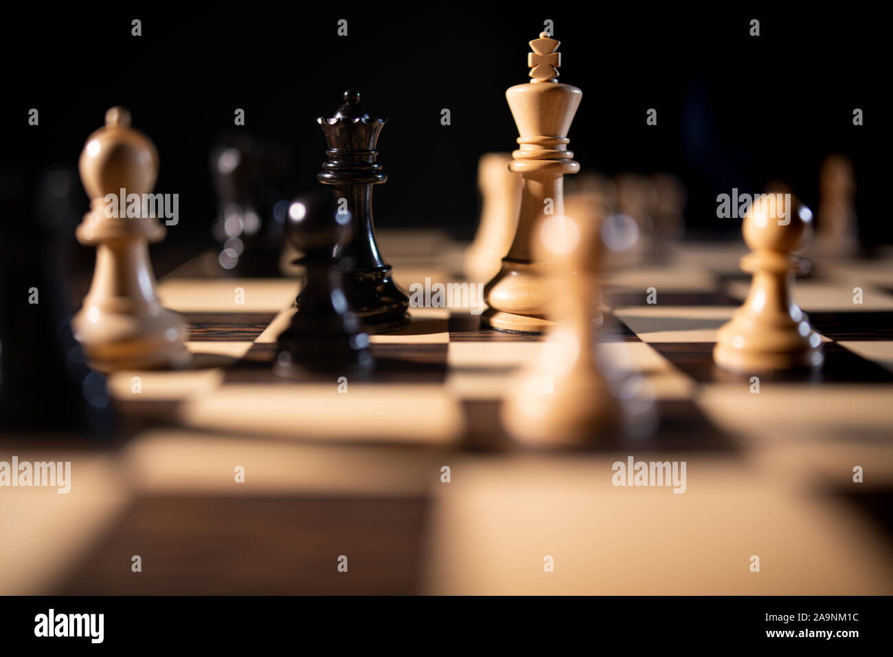 Chiudere fino a scacchi pezzi su una scacchiera, in rappresentanza di strategia e tattica Foto Stock