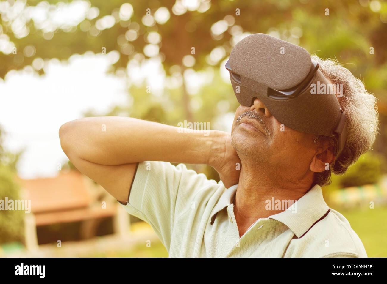 Senior uomo con VR google vetro per esercizio, Outdoor - Concetto di fitness utilizzando le nuove tecnologie da parte di persone anziane - old men stretching mani da Foto Stock