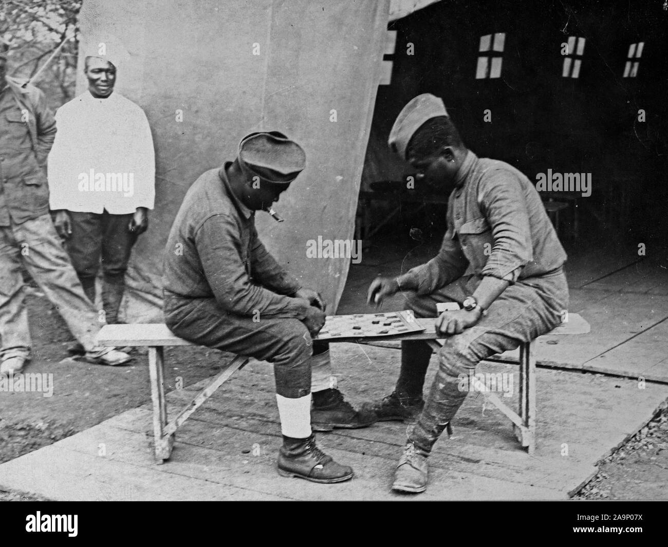 WW I foto - Colorate / africana di truppe americane - STATI UNITI Soldati colorati in Francia impegnati in un gioco della dama di fronte un YMCA hut in uno dei campi sulla parte anteriore Asine ca. 1917-1918 Foto Stock