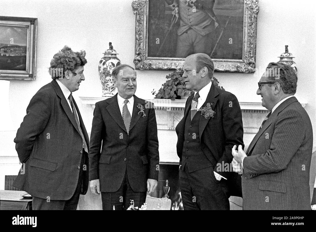 1976, marzo 17 - Sala Blu - La Casa Bianca - Gerald Ford, Liam Cosgrave, Garret FitzGerald, Henry Kissinger - standing, parlando vicino al camino Foto Stock