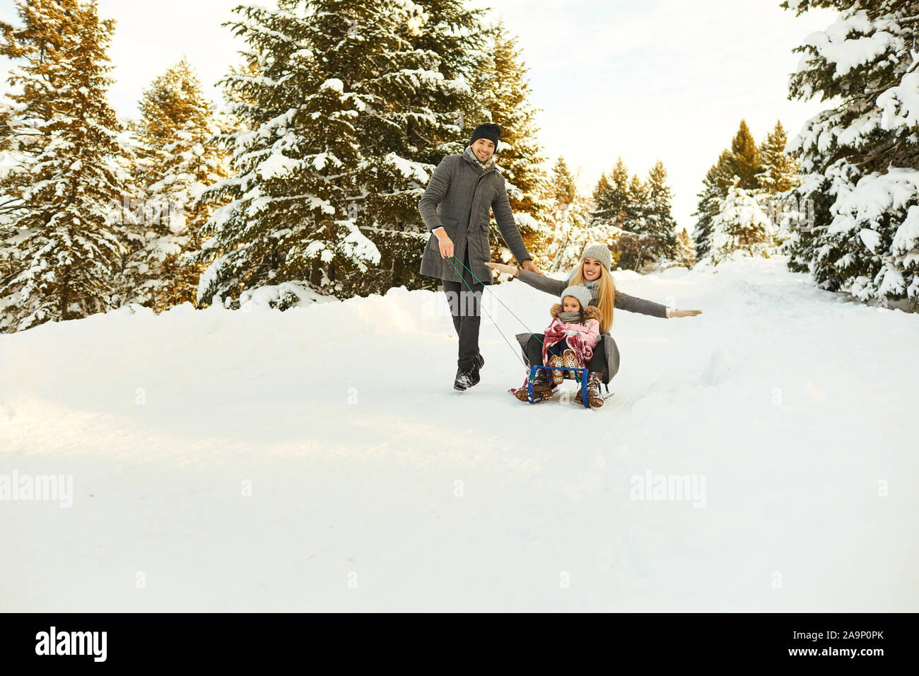 Giocoso i genitori con bambini nel bosco invernale Foto Stock