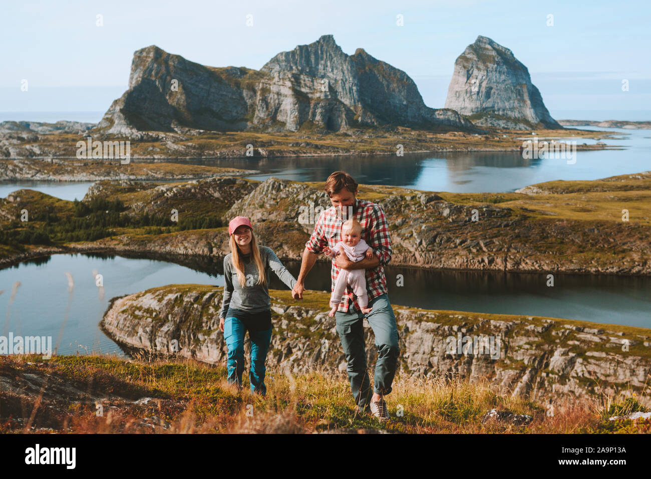 Famiglia giovane con un neonato bambino viaggia in Norvegia montagna vacanze outdoor l uomo e la donna che cammina con il bambino su uno stile di vita sano Helgeland isole Foto Stock