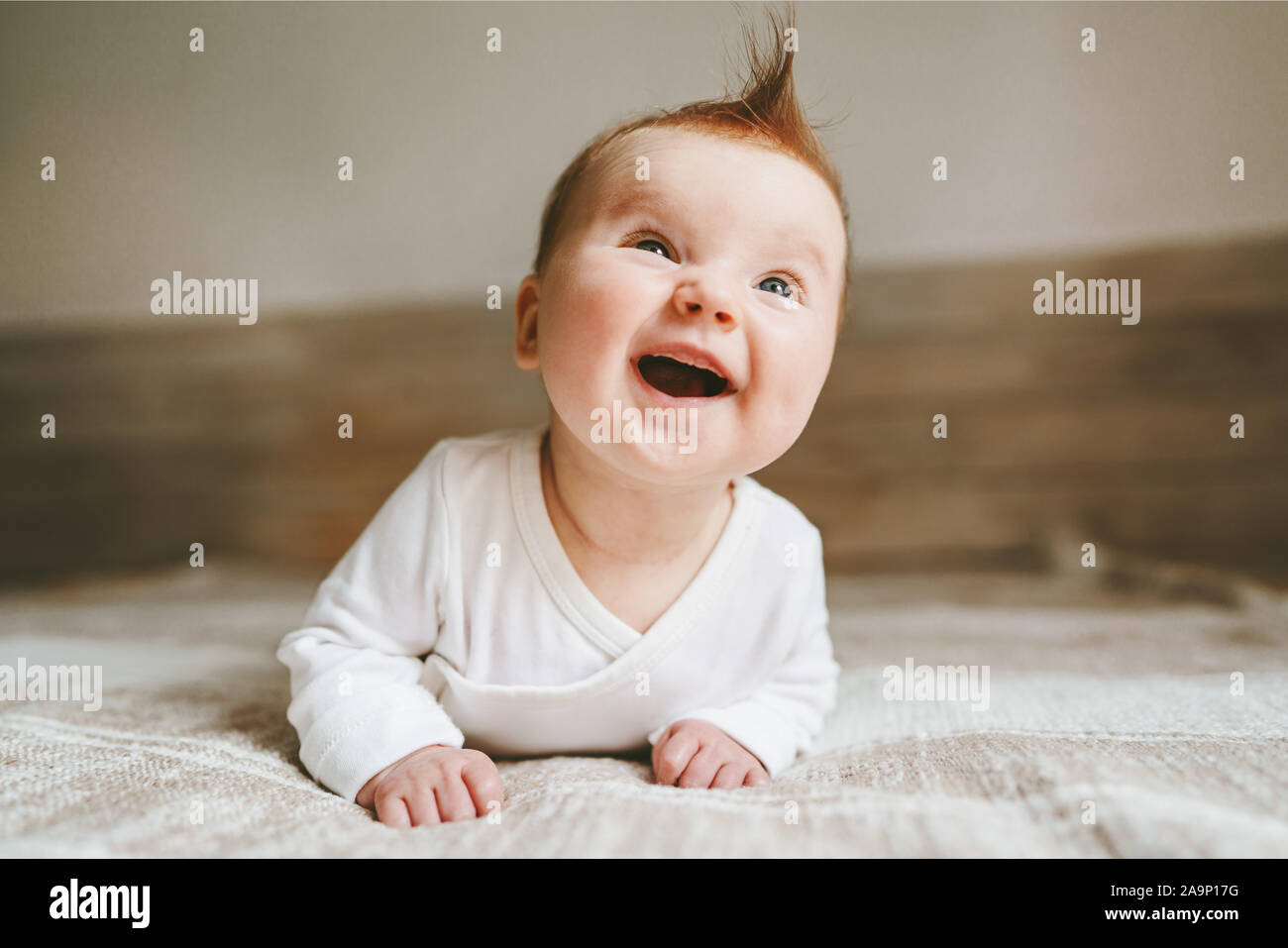 Happy baby strisciando in camera da letto lo stile di vita della famiglia sorridente ridere bambino 3 mese vecchio kid emozioni positive Foto Stock