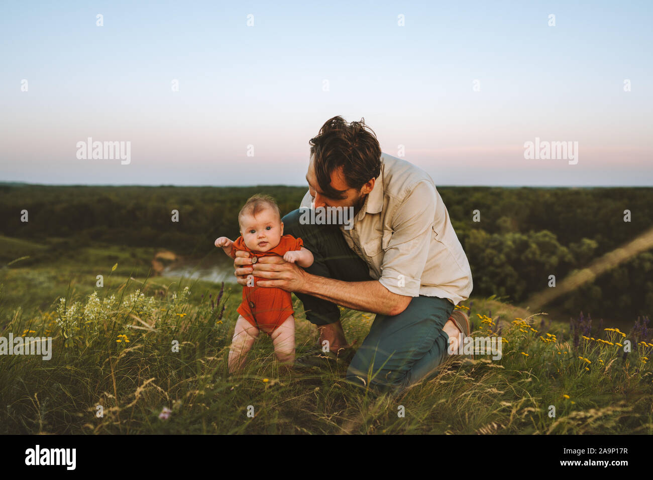 Felice padre di famiglia e il bambino all'aperto lo stile di vita della famiglia papà e figlio camminare sull'erba vacanze estive con kid genitorialità infanzia concetto Padri d Foto Stock