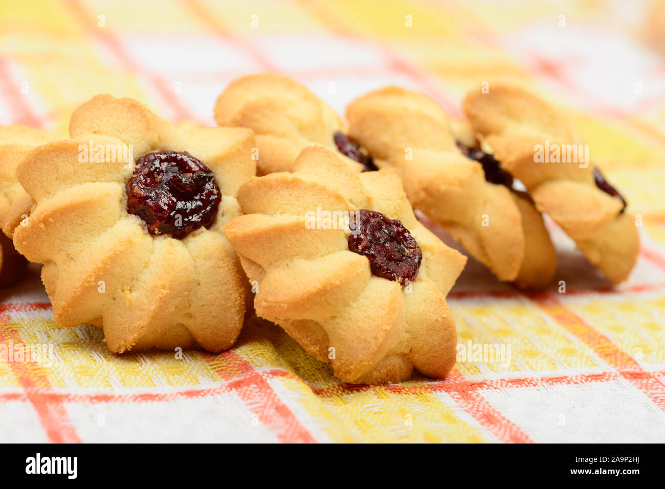 Gruppo di biscotti fatti in casa con la marmellata sulla tovaglia close up Foto Stock