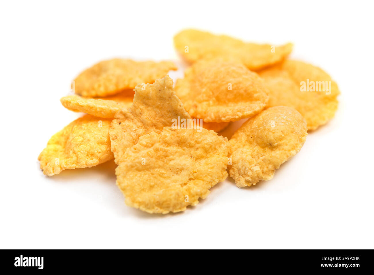 Cornflakes macro isolato. Piccola pila di fiocchi di mais su sfondo bianco Foto Stock