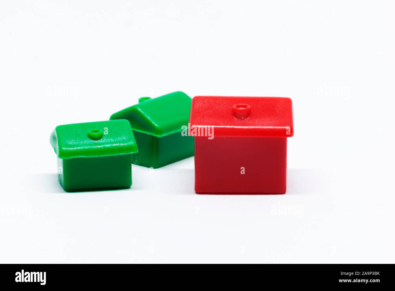 Case e alberghi per il gioco monopolio su fondo bianco, simbolo di ricchezza Foto Stock