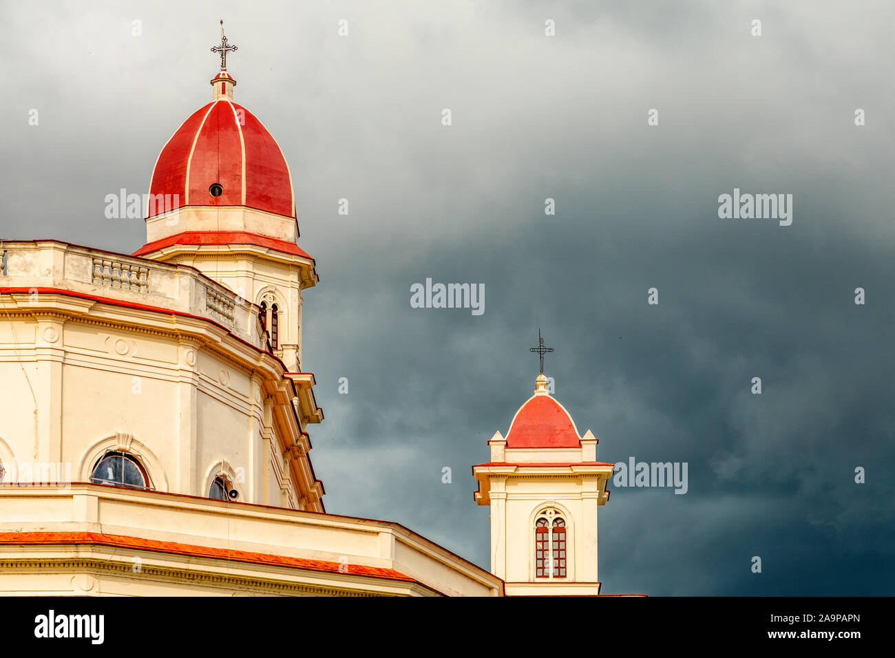 Tappata rosse torri della basilica in onore di Nostra Signora della Carità con black thunder nuvole sopra, El Cobre, Santiago de Cuba, Cuba Foto Stock