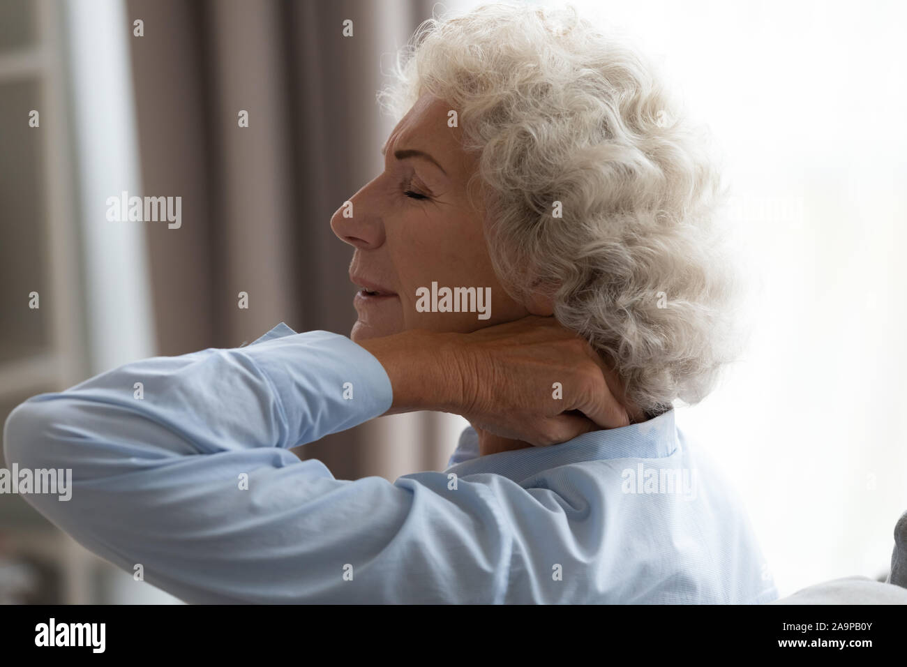 Stanco senior nonna sfregamento torcicollo che soffre di fibromialgia dolore Foto Stock