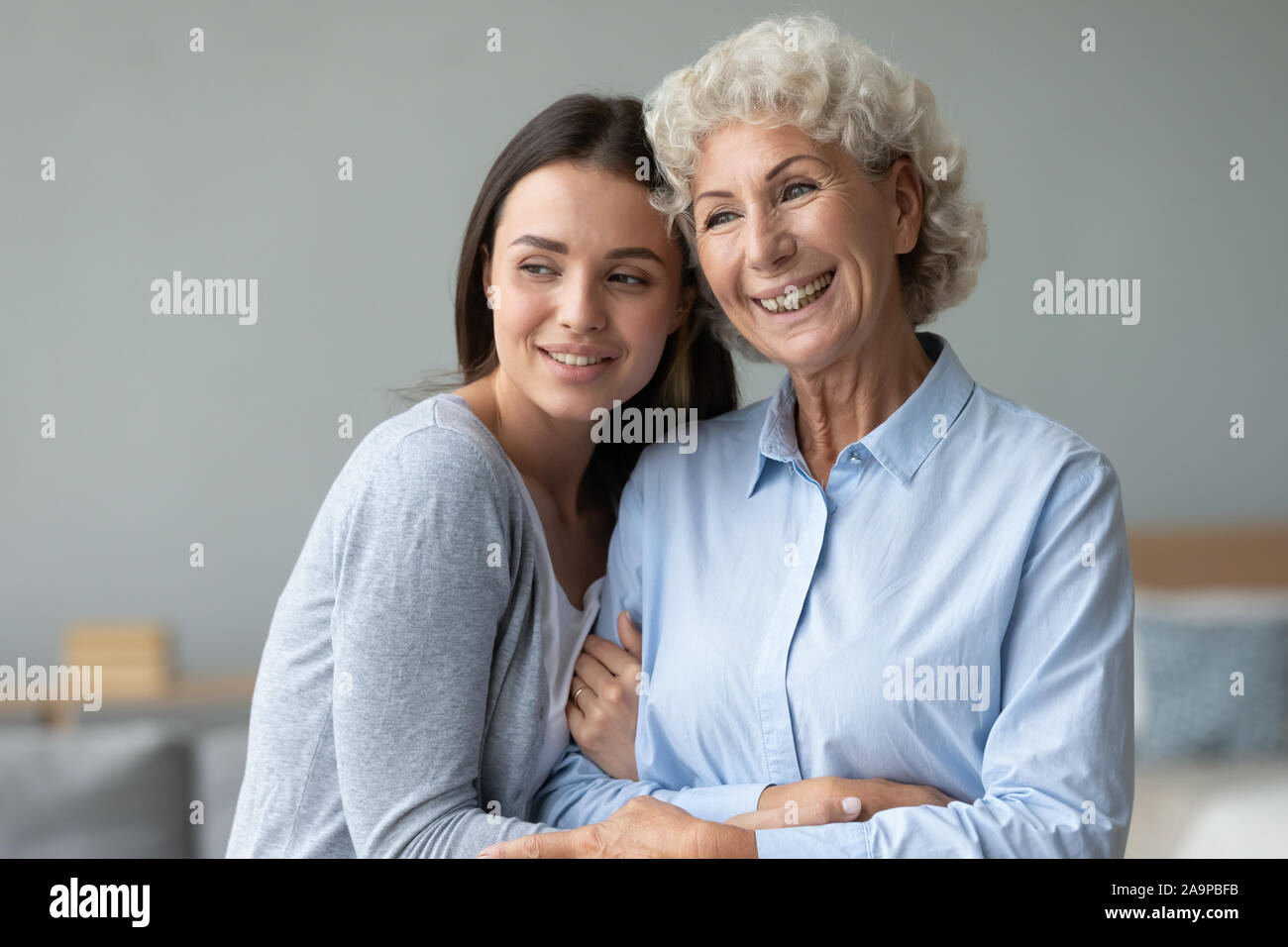 Giovane nipote e felice vecchia nonna incollaggio guardando lontano sognando Foto Stock
