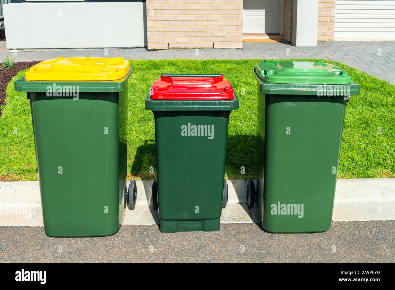 Australian impennarsi in contenitori con coperchi colorati per organici generale dei rifiuti e il riciclaggio dei prodotti forniti dal consiglio comunale locale Foto Stock