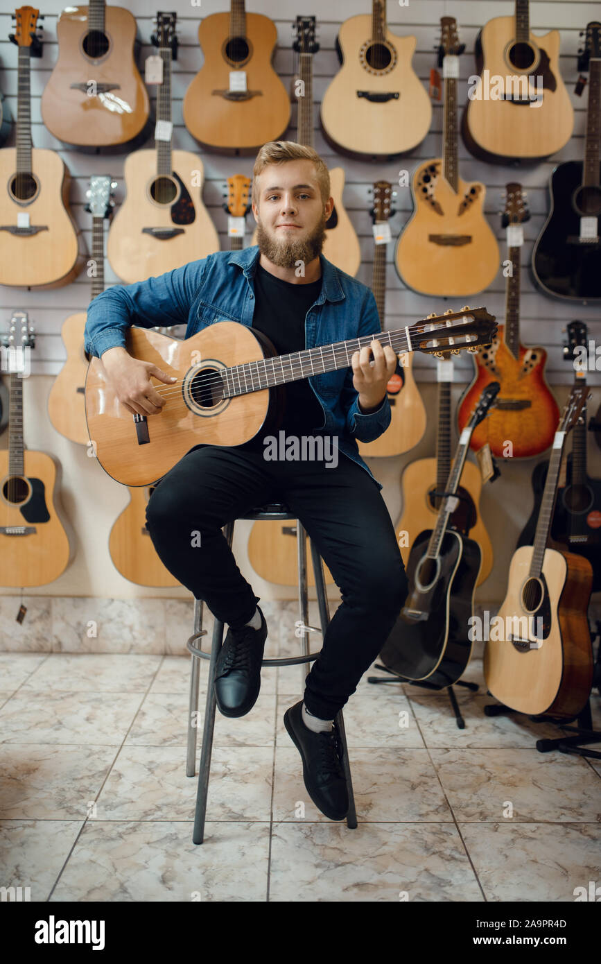 Il chitarrista suona sulla chitarra acustica in music store Foto Stock