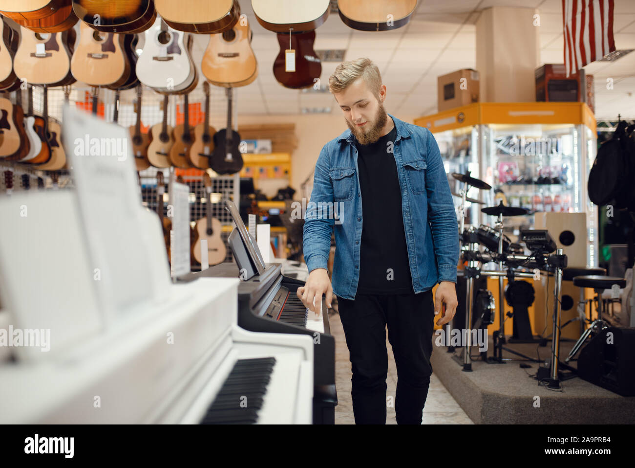 Giovane musicista pone al pianoforte in music store Foto Stock