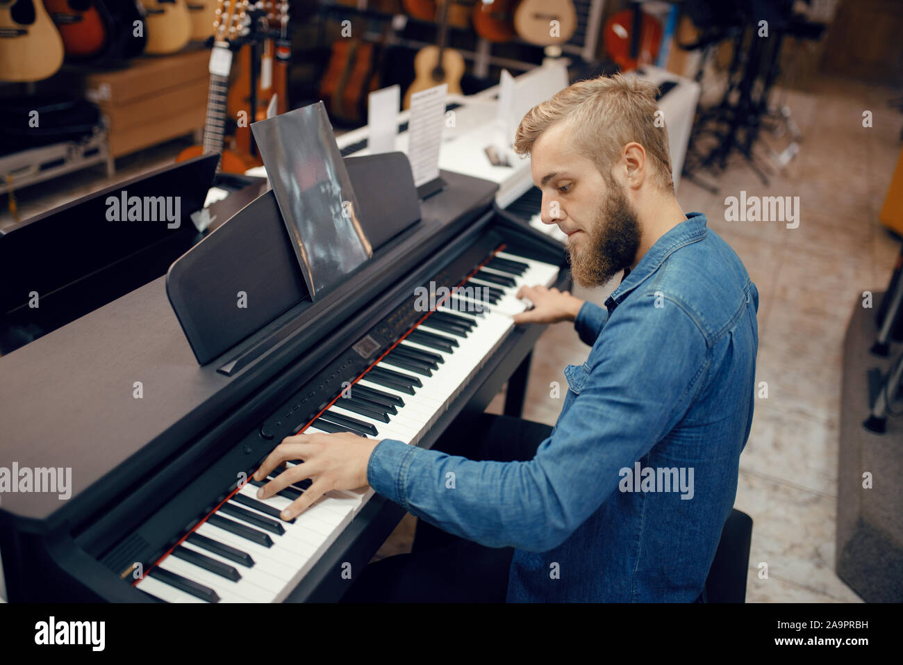 Musicista cercando di riprodurre sul pianoforte in music store Foto Stock