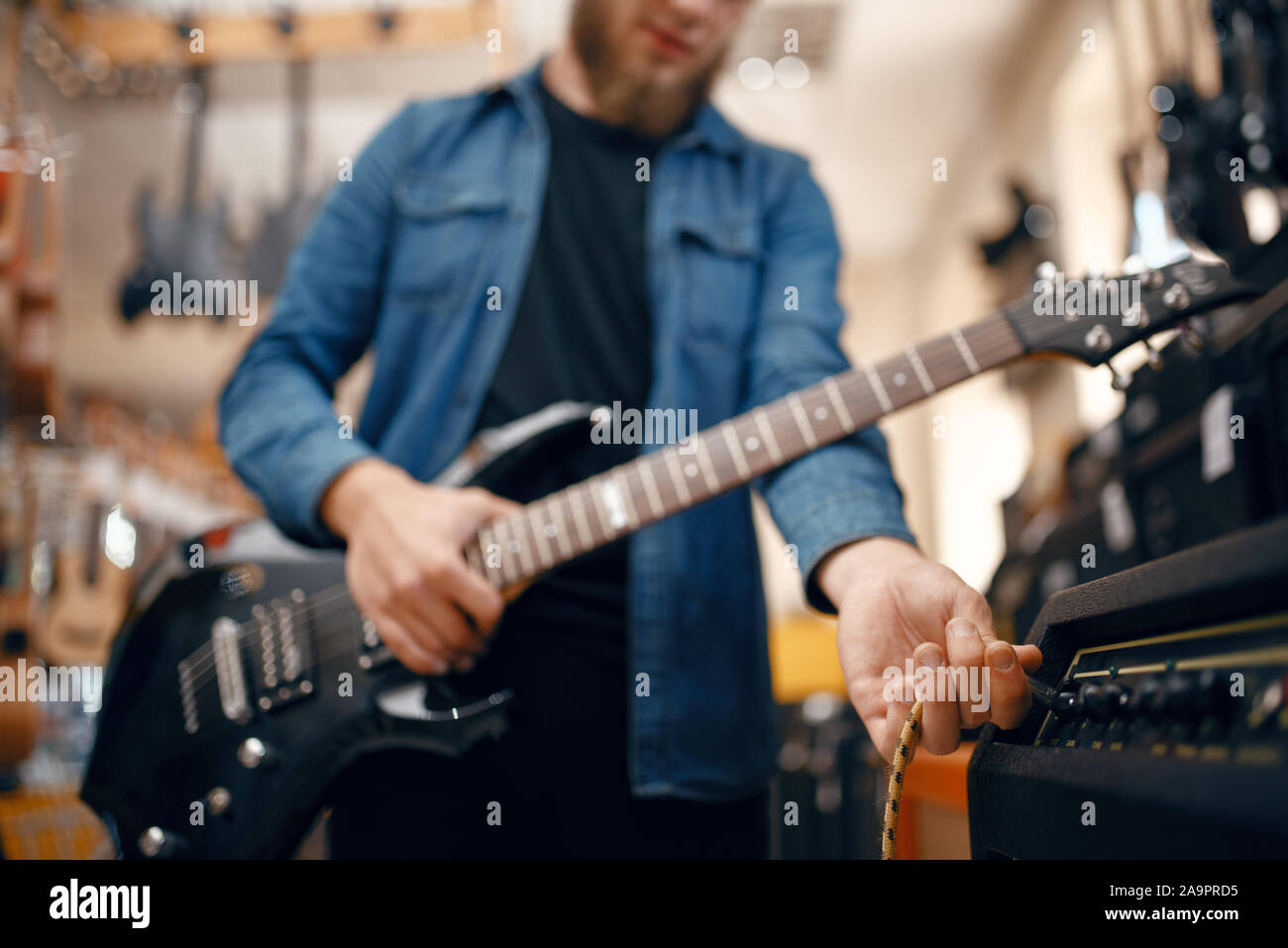 Il chitarrista suona sulla chitarra elettrica in music store Foto Stock