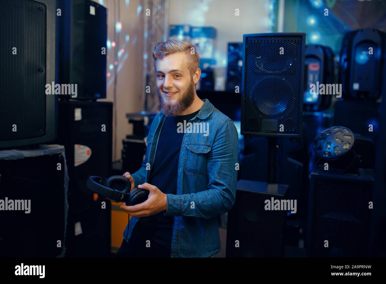 Giovane musicista la scelta di auricolari in music store Foto Stock