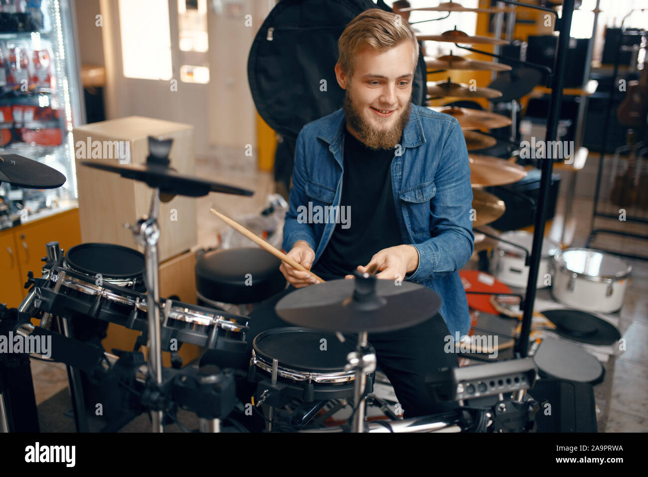 Giovane musicista suona sul tamburo impostata in music store Foto Stock
