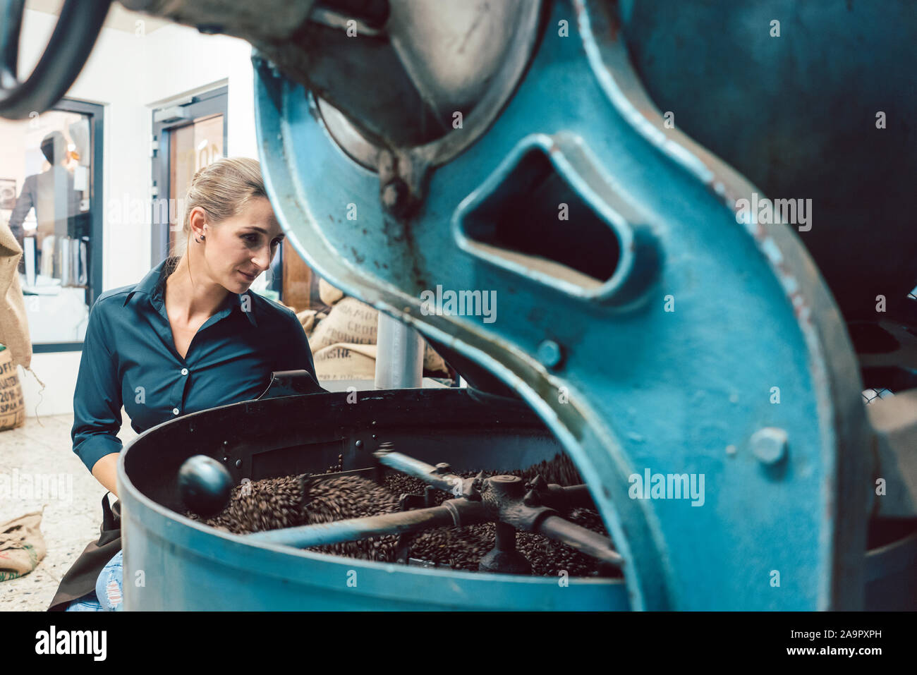 Donna di funzionamento di torrefazione del caffè Foto Stock
