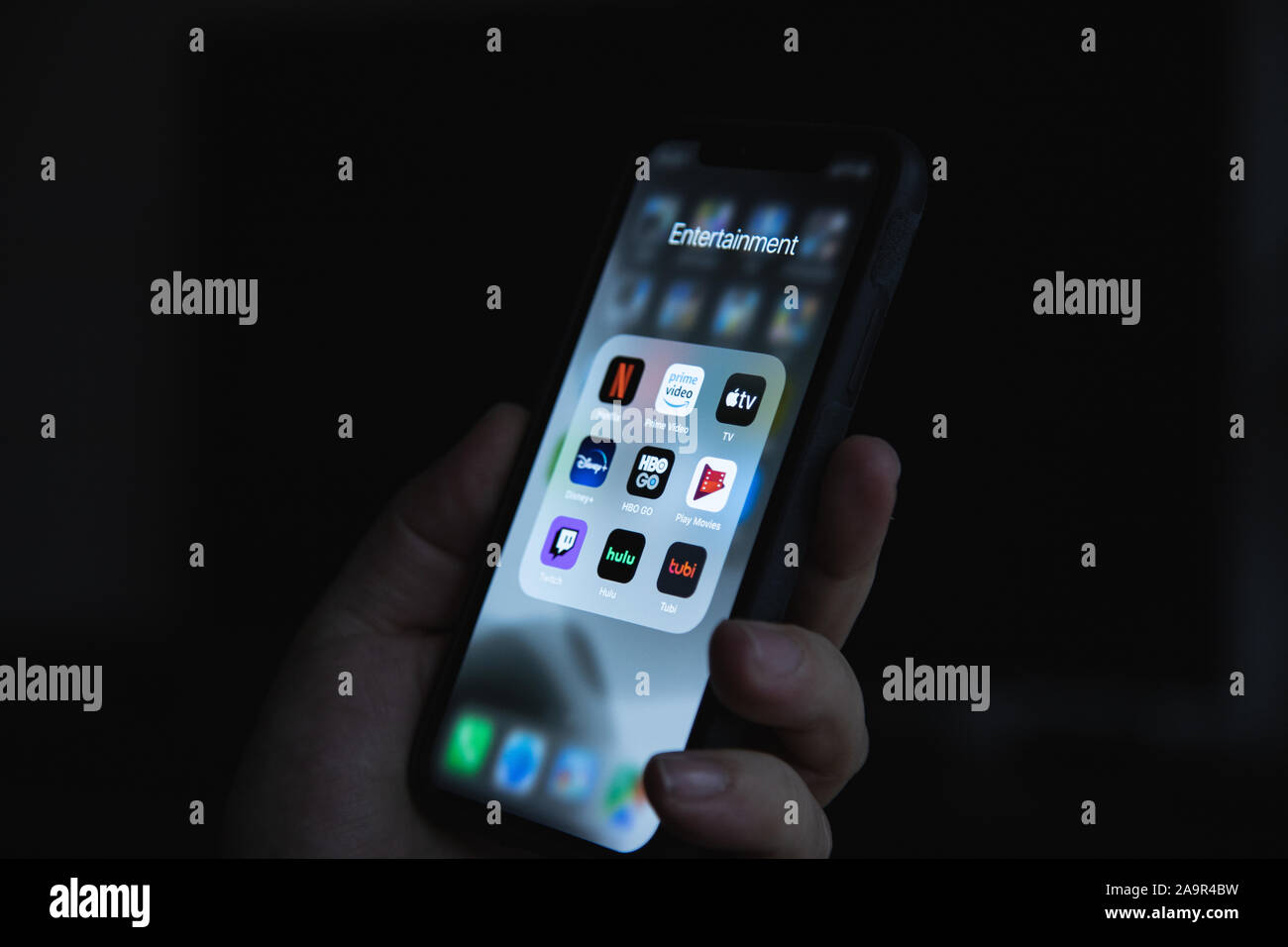 Apple XS smartphone a portata di mano con il gruppo di applicazioni di streaming di Netflix, HBO, Disney Plus, Apple TV Foto Stock