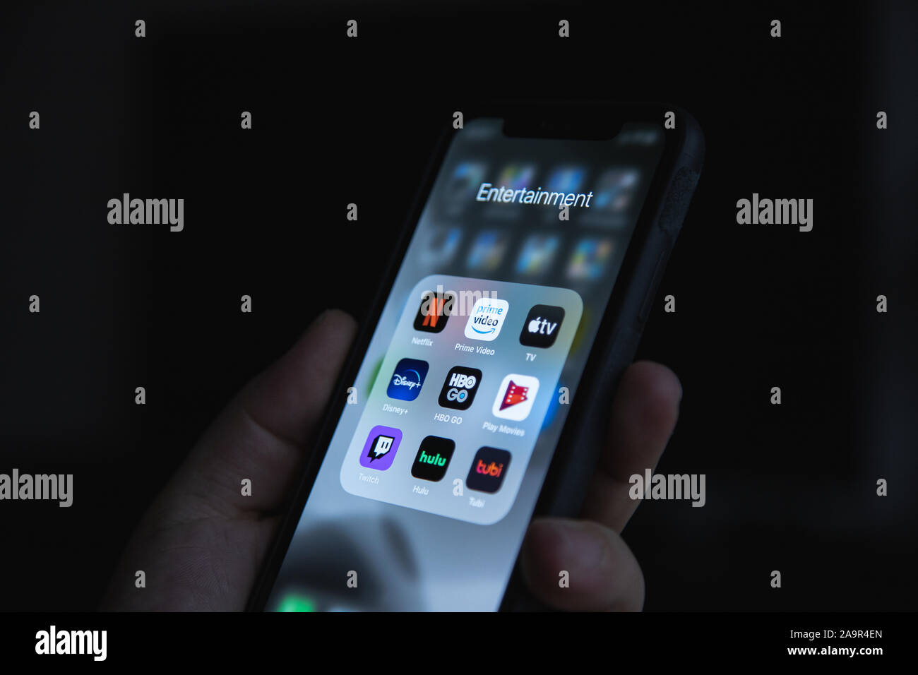 Apple XS smartphone a portata di mano con il gruppo di applicazioni di streaming di Netflix, HBO, Disney Plus, Apple TV Foto Stock