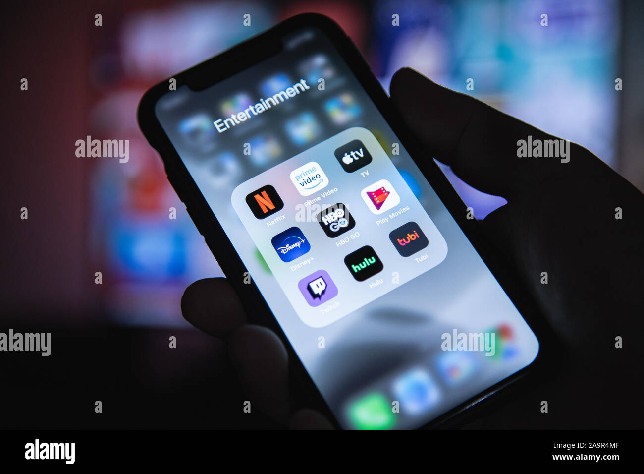 Apple XS smartphone a portata di mano con il gruppo di applicazioni di streaming di Netflix, HBO, Disney Plus, Apple TV Foto Stock