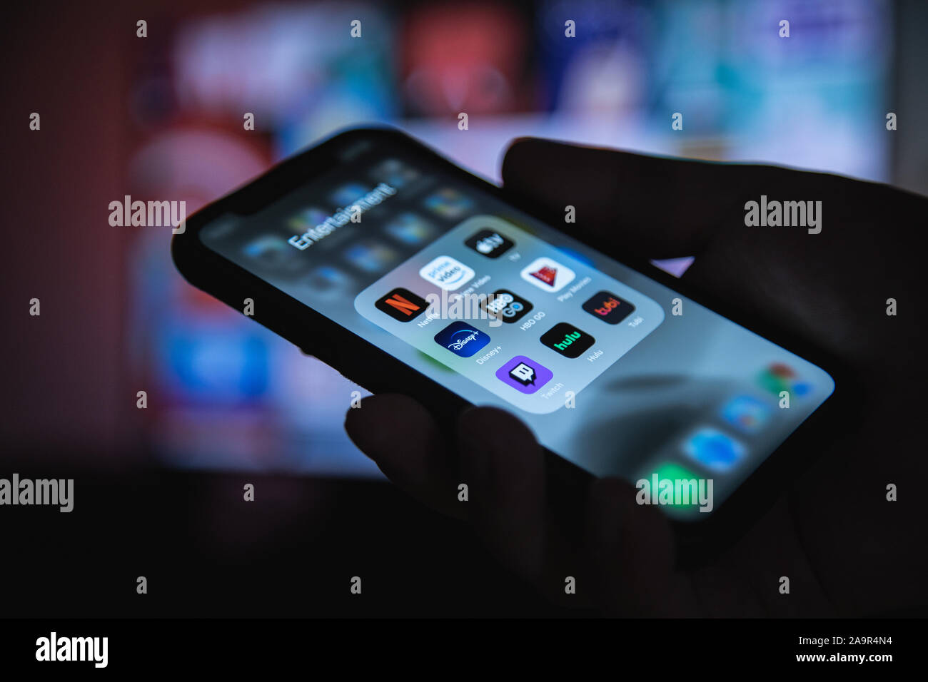 Apple XS smartphone a portata di mano con il gruppo di applicazioni di streaming di Netflix, HBO, Disney Plus, Apple TV Foto Stock