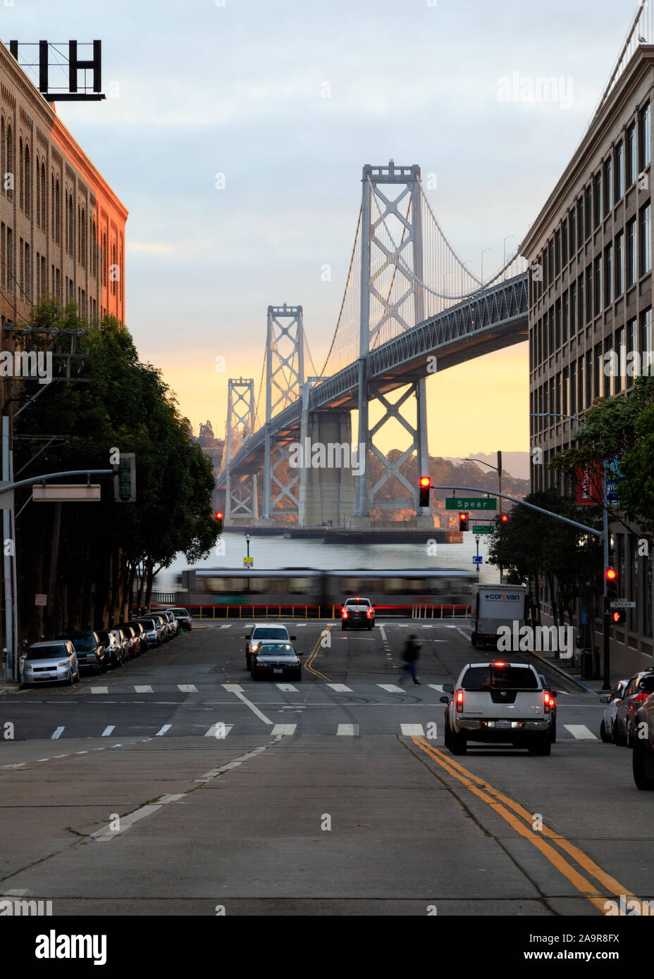 Vista di Oakland Bay Bridge dalle strade di San Francisco, California, in mattinata con un carrello che passa e il carrello si è fermato a luce Foto Stock