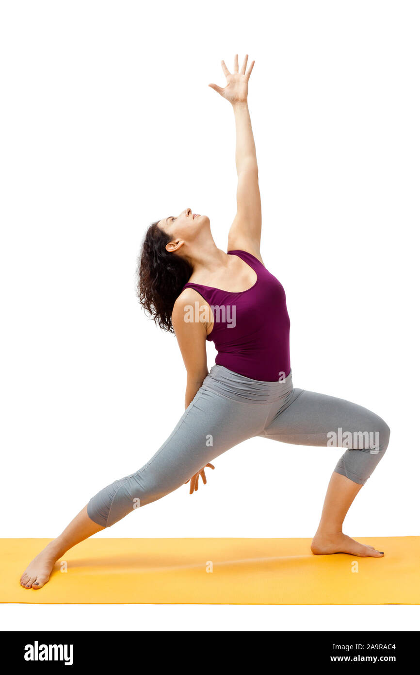 Eine huebsche Frau, die auf einer Isomatte Yoga-Uebungen durchfuehrt Foto Stock