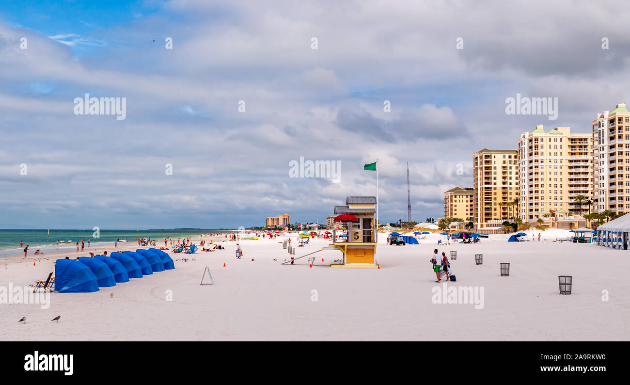 La gente di nuoto nel Golfo del Messico e rilassante sulla spiaggia con gli alberghi in background su una soleggiata giornata di caduta, Clearwater Beach, Florida, Stati Uniti d'America Foto Stock