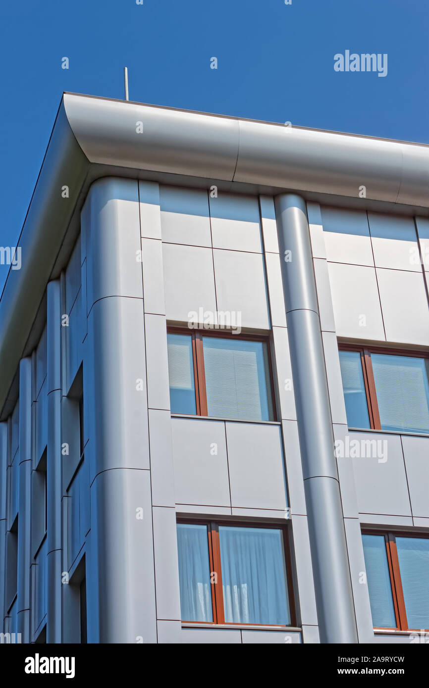 Parte alta del nuovo e moderno ufficio futuristico edificio con colore metallico decorazione in condizioni di luce solare intensa sullo sfondo del cielo blu Foto Stock