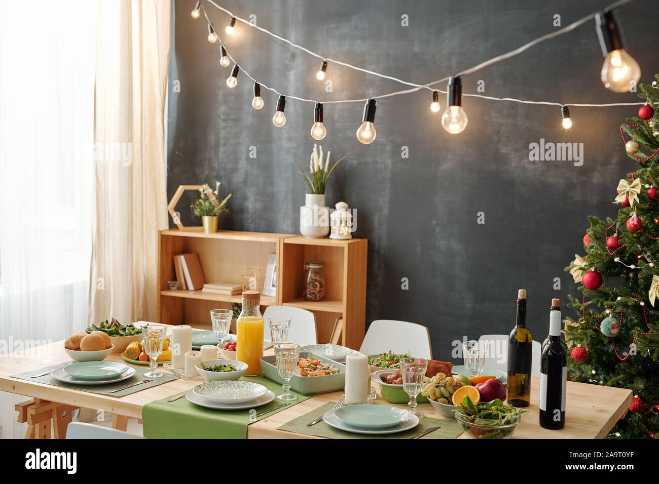 Tabella di festa è servita per la festa di Natale con lampade pendenti oltre il pasto Foto Stock