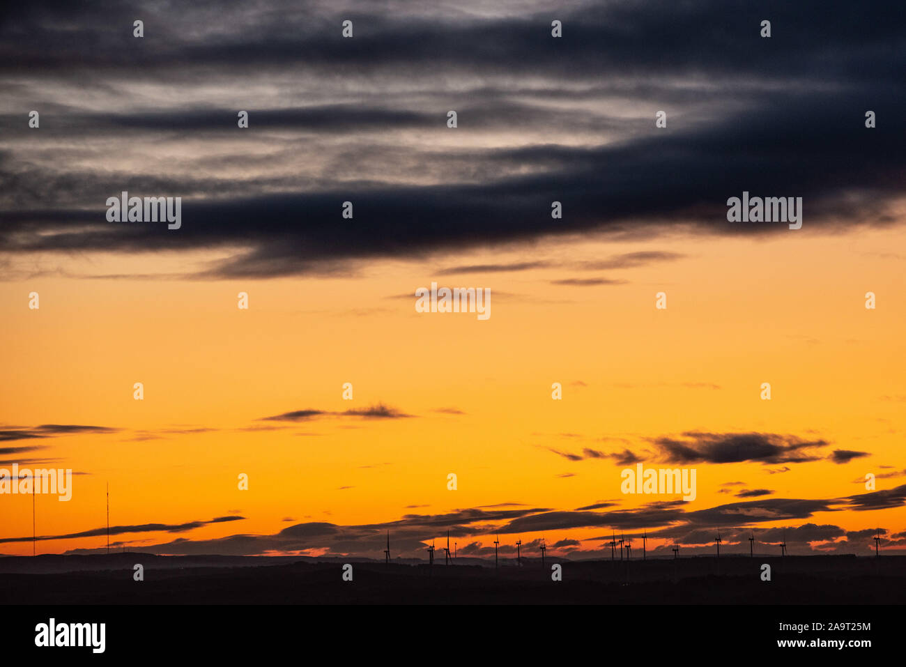 Tramonto dal Bathgate colline con le turbine eoliche in distanza Foto Stock