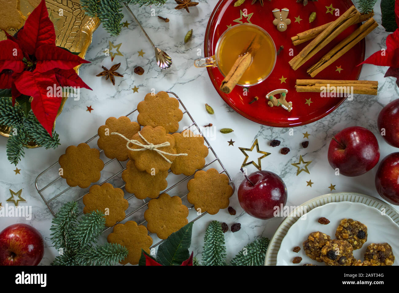 Fotografia di cibo di una tavola di marmo alto decorato con un tocco di eleganza raffinata rosso e oro Chistmas cookie e spezie Foto Stock