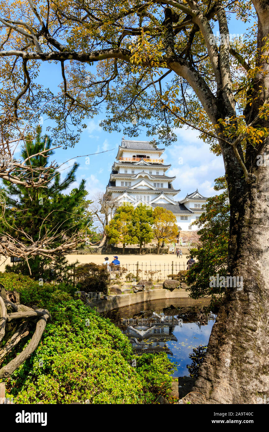 Fukuyama castle in Giappone. Il castello di mantenere nel tempo primaverile incorniciato da alberi e stagno dal piccolo giardino in Honmaru. Cielo blu sullo sfondo. Foto Stock