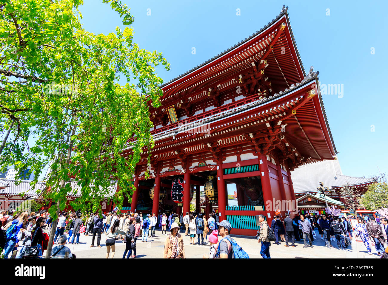 Tokyo, il santuario di Asakusa e il tempio di Sensoji. La massiccia Hozomon, secondo cancello con la sala principale dietro. Primo piano affollate di persone. Blue sky. Foto Stock