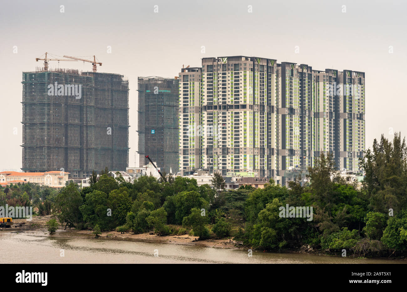 Ho Chi Minh City Vietnam - Marzo 12, 2019: canzone Sai Gon river. Sviluppo e costruzione di alti edifici di appartamenti dietro il carter inferiore e verde Foto Stock
