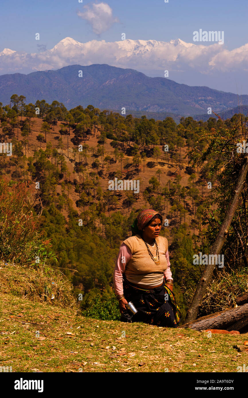 Donna indiana con l'Himalaya innevato picchi in background come si vede dal villaggio Lamgara, Kumaon Hills, Uttarakhand, India Foto Stock