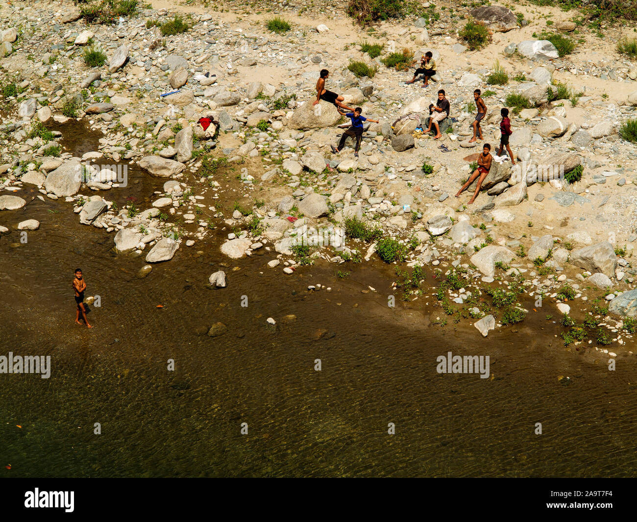 Indian ragazzi giocare nel calore del mezzogiorno sul fiume Goula vicino villaggio Khansyun, Uttarakhand, India Foto Stock