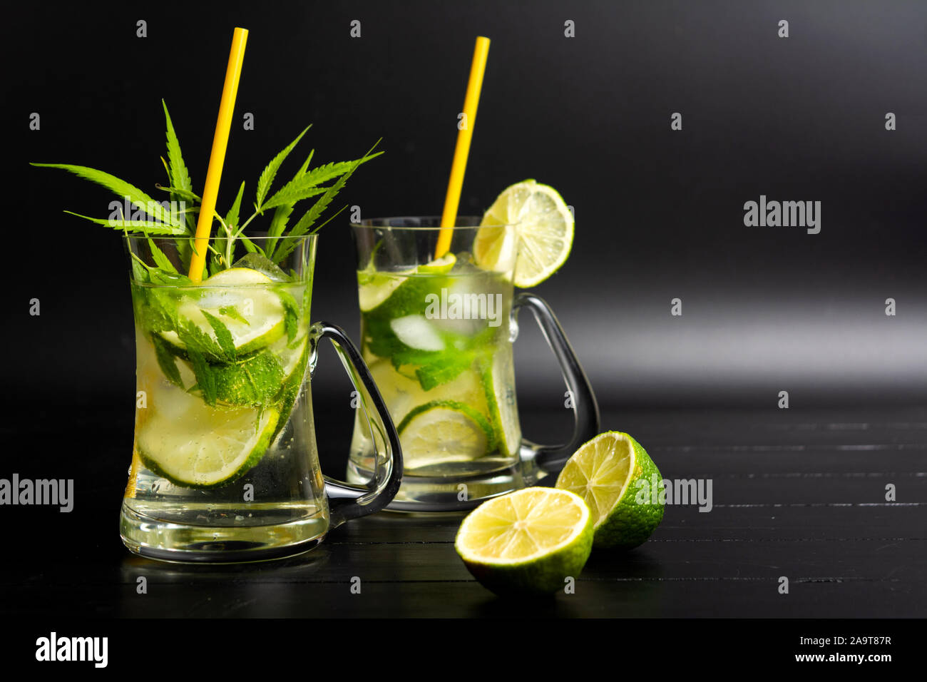 Cocktail di lime con la marijuana in un bicchiere su sfondo scuro Foto Stock