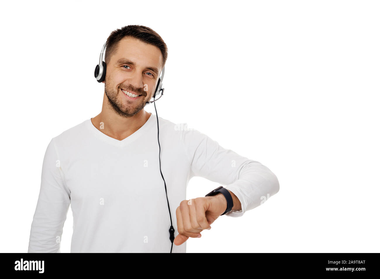 Call center lavoratore isolato su sfondo bianco. Sorridendo gentile rappresentante del servizio di assistenza clienti tramite auricolare e Mostra orologio. Salva il tuo tempo - Chiama assistenza clienti e supporto Foto Stock