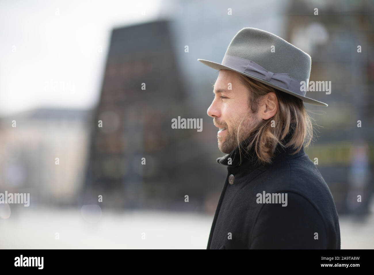 Uomo con cappello, cappotto e barba al di fuori a piedi Foto Stock