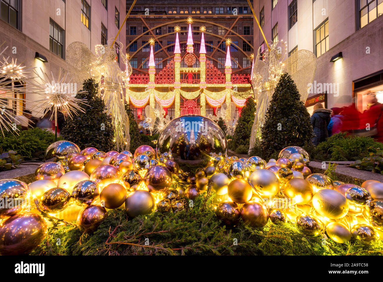 Stagione di Natale decorazioni presso il Centro Rockefeller Plaza con vista di Saks Fifth Avenue holiday light display. Midtown Manhattan, a New York City, NY Foto Stock