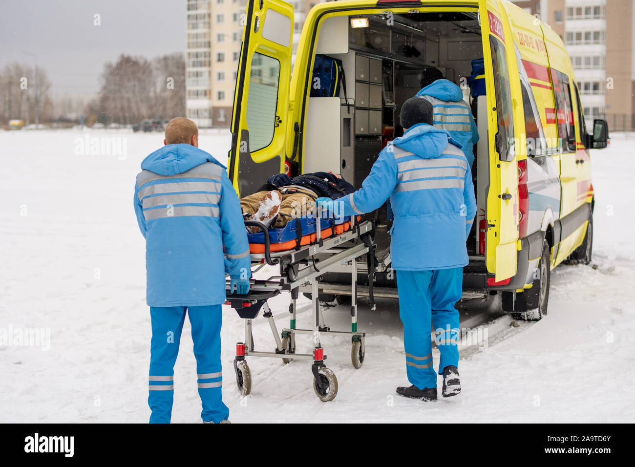 I paramedici spingendo barella con fisso uomo incosciente in ambulanza Foto Stock