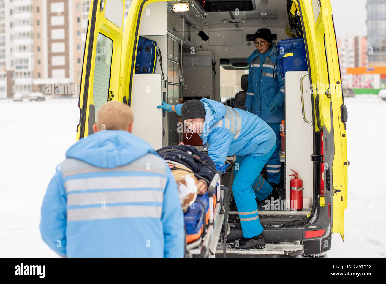 I paramedici getting barella con fisso uomo incosciente in ambulanza Foto Stock