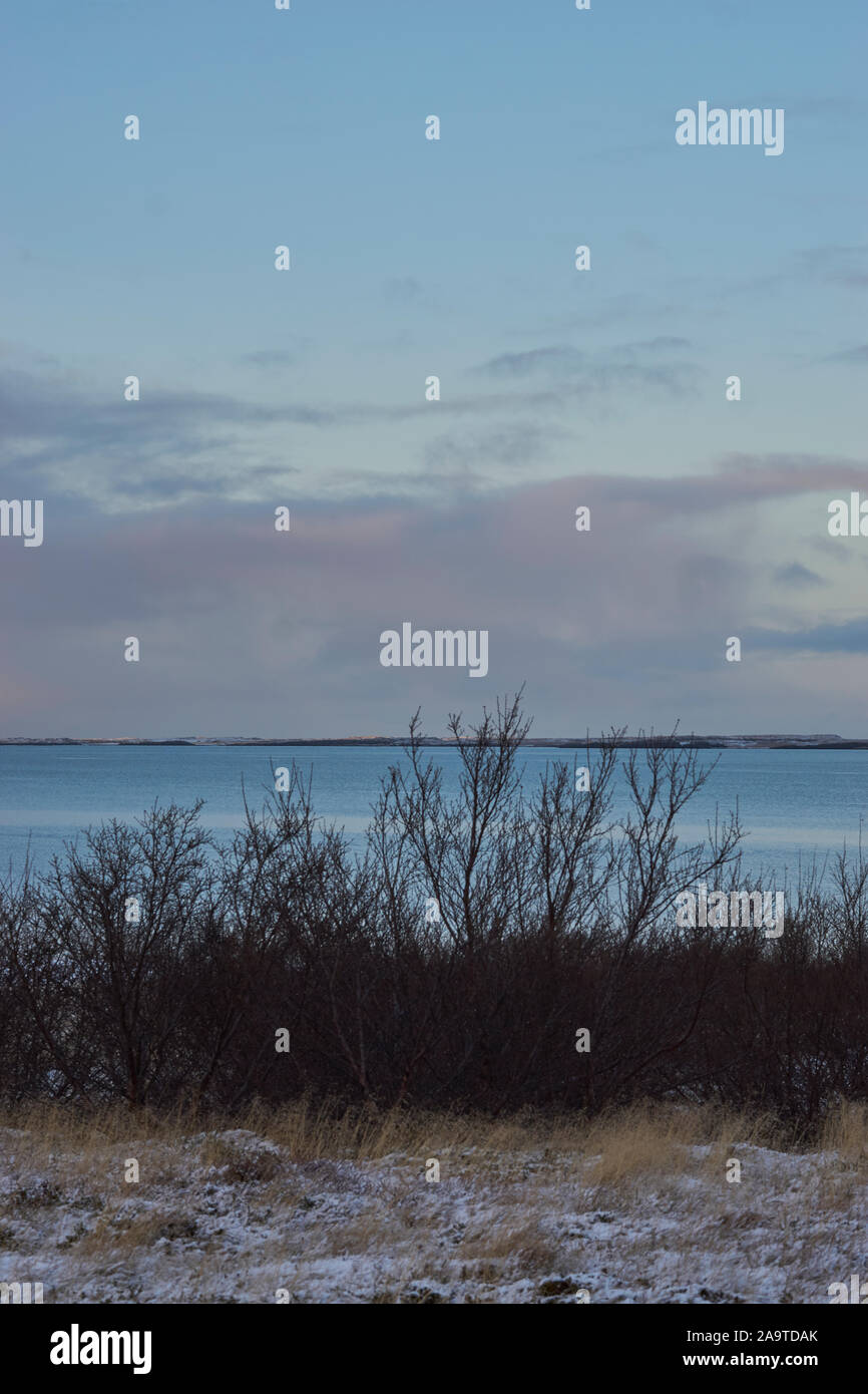 Vista del paesaggio in Borgarfjordur in Western in Islanda in condizioni di scarsa illuminazione di metà-winteer, montagne innevate e cielo drammatico Foto Stock