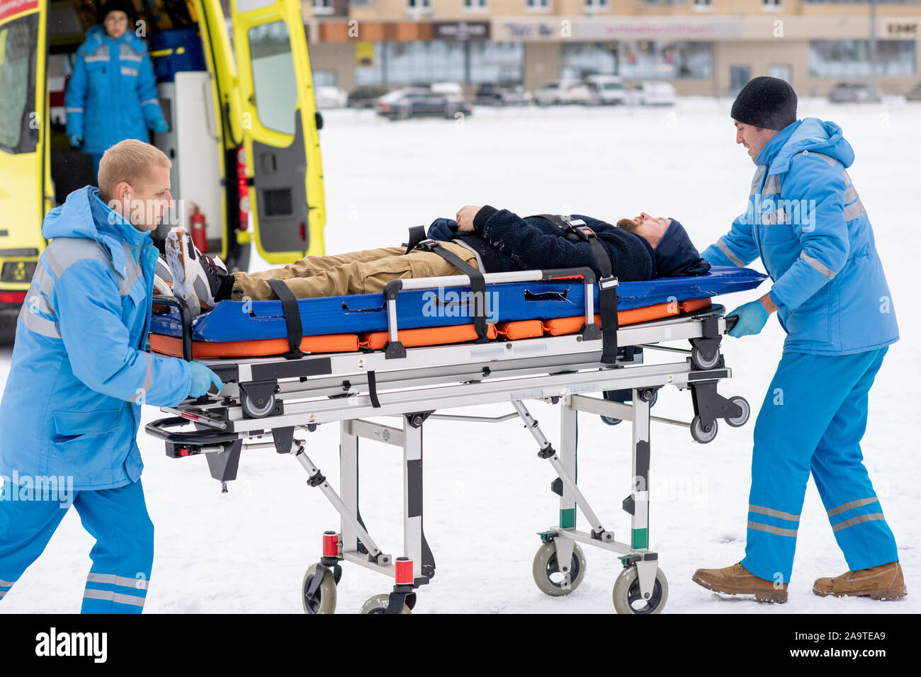 Due paramedici spingendo malati inconscio uomo sulla barella verso l'ambulanza Foto Stock