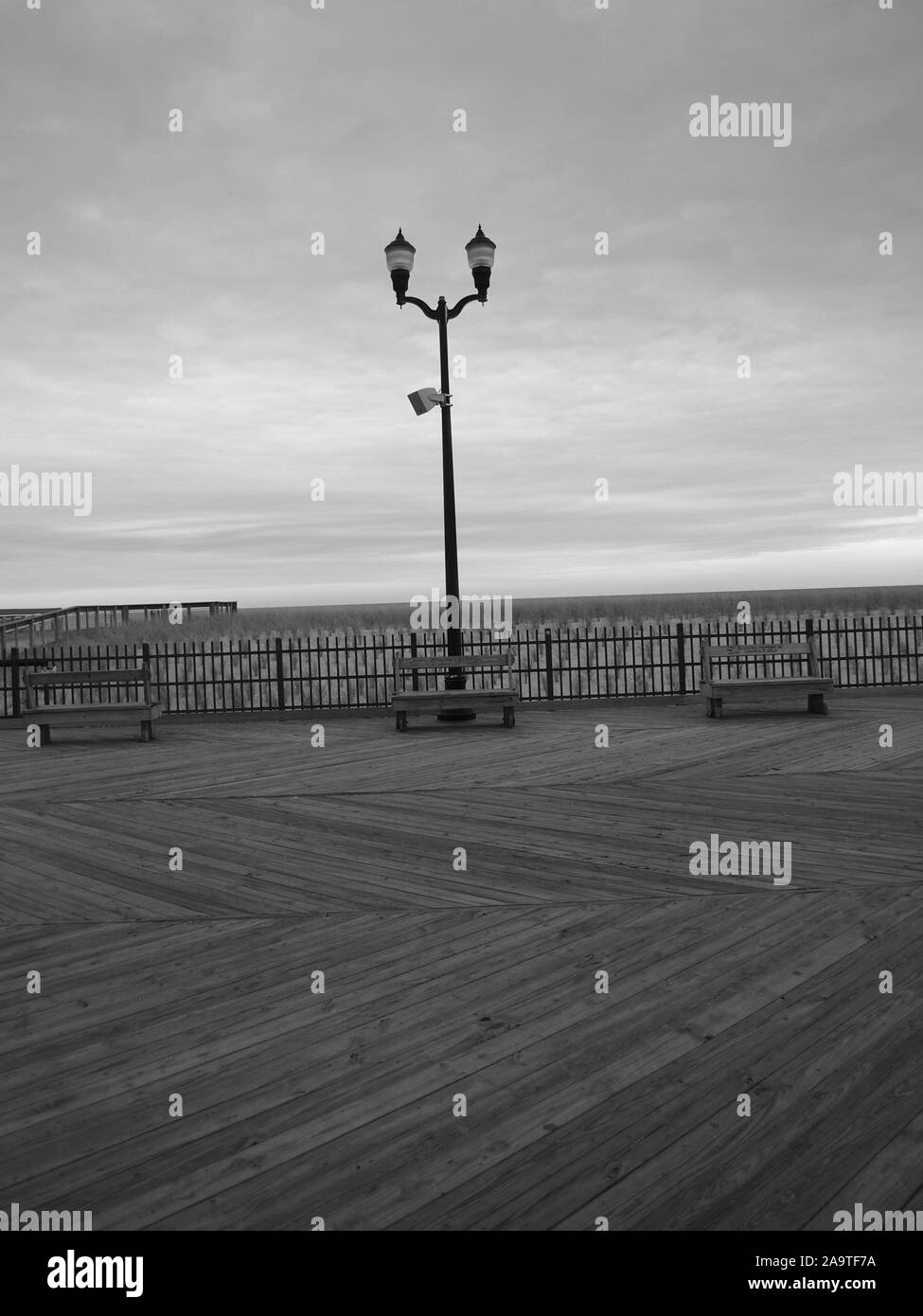 Lone palo della luce sul mare Heights, New Jersey, boardwalk torreggia su empty oceanside panche Foto Stock