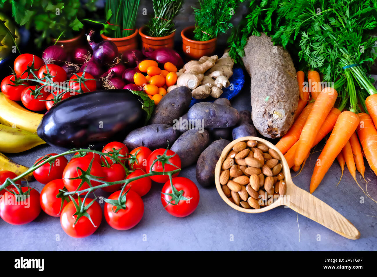 Set di deliziosi ortaggi freschi compresi i pomodori, mandorle, patate dolci, igname, manioca, le carote e le erbe aromatiche Foto Stock