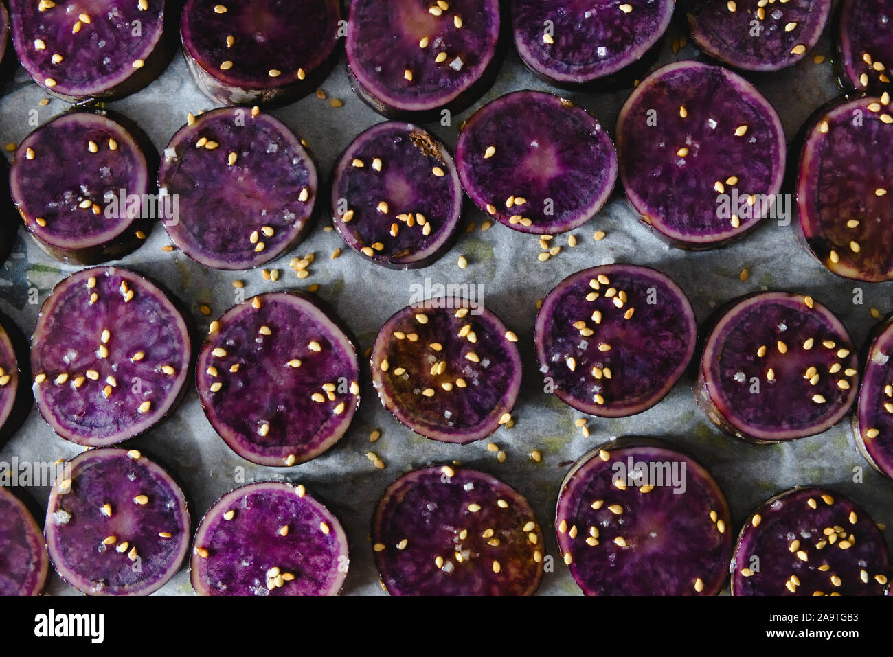 Fette di viola le patate dolci cosparsi di semi di sesamo Foto Stock